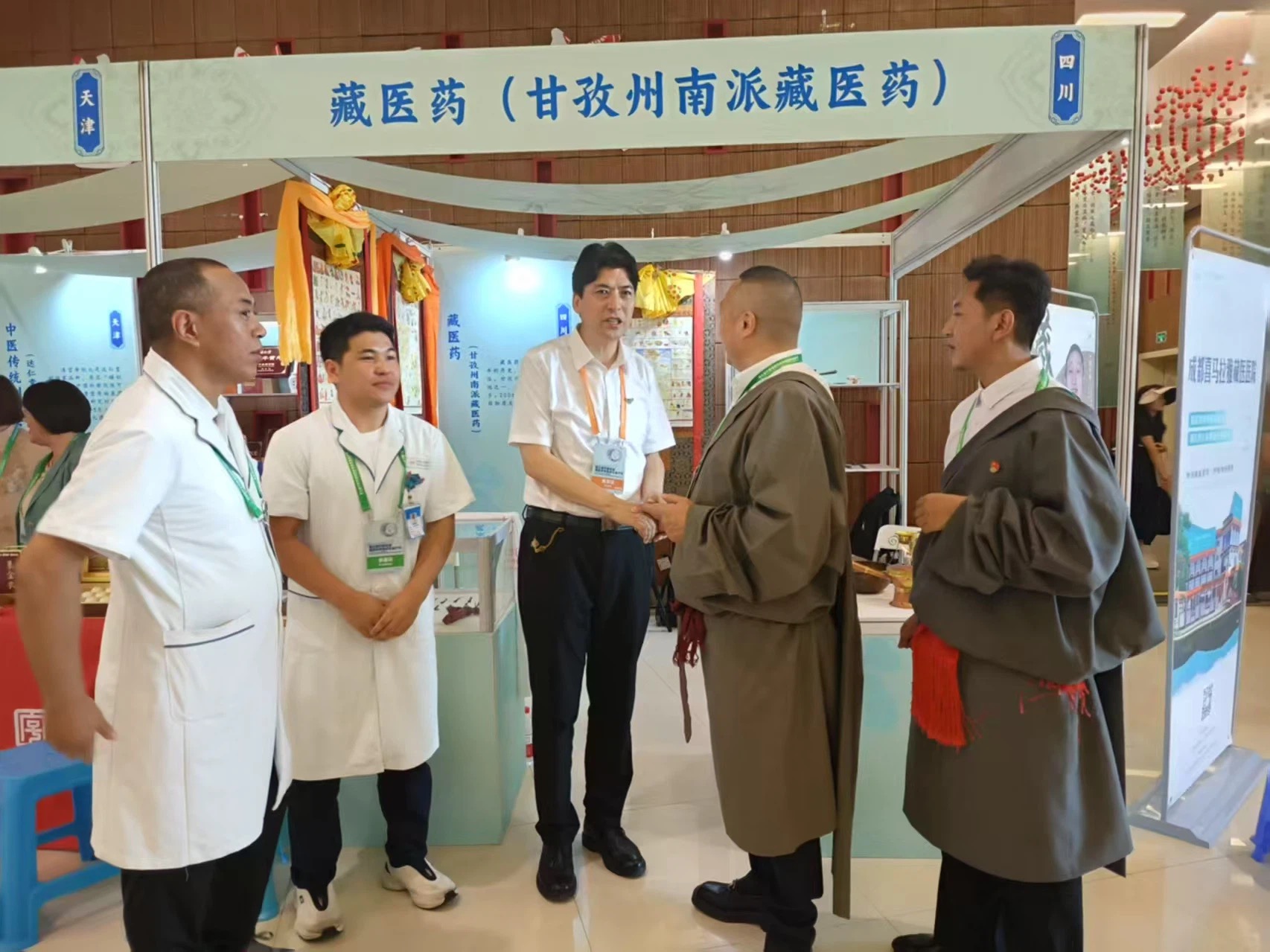 南派藏医药展位前,青佩院长与甘孜州文旅局领导握手交谈