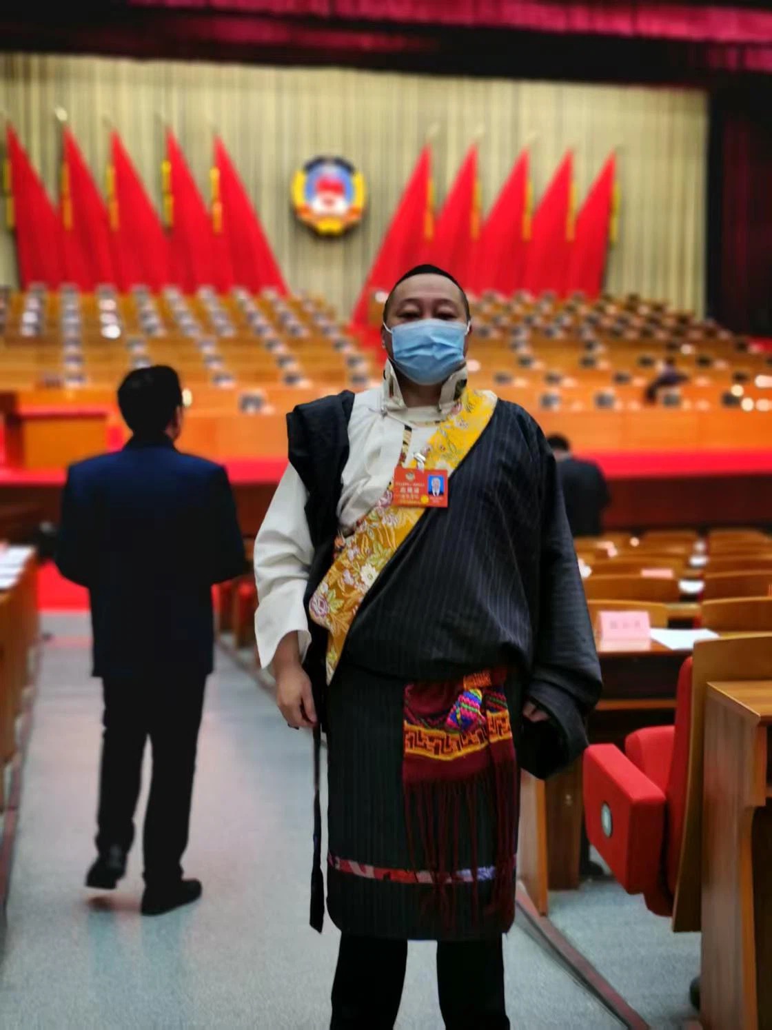 四朗青佩委员站在政协会议主席台前
