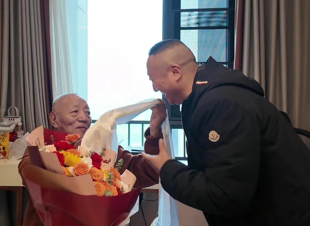青佩院长手捧哈达与鲜花献予老活佛